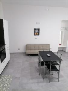 a living room with a table and chairs and a couch at Darsena Apartments1 in Molfetta +4 photos