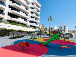 a playground in front of a large apartment building at Sol Blanco in Arenales del Sol