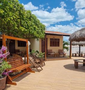 加利紐斯的住宿－Pousada Rio Aratuá，庭院设有长椅和桌子,房屋设有