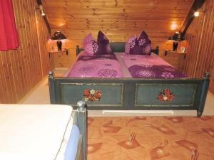 - une chambre avec un lit doté de draps violets et d'oreillers violets dans l'établissement Holiday home with terrace in the Black Forest, à Sankt Georgen im Schwarzwald