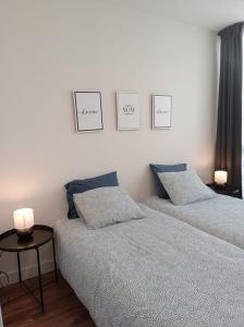 two beds in a bedroom with three pictures on the wall at First Row Sea Estepona in Estepona