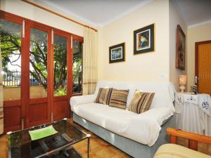 ein Wohnzimmer mit einem weißen Sofa und einem Glastisch in der Unterkunft Belvilla by OYO Cora in Port d'Alcúdia