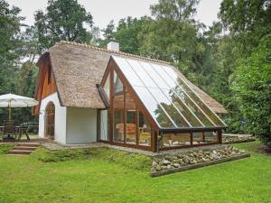 una pequeña casa con un gran techo de cristal en Exclusive holiday home in Uelsen with conservatory, en Uelsen