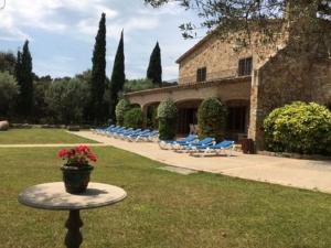 d'une terrasse avec des chaises et une table agrémentée d'un pot de fleurs. dans l'établissement Belvilla by OYO Villa Can Boira, à Santa Cristina d'Aro