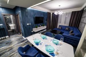 a living room with a blue couch and a table at Apartmani Milanovic in Bijeljina