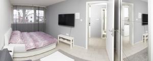 a bedroom with a bed and a tv on the wall at Apartment Sven in Vinkovci