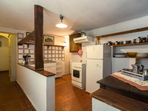 cocina con nevera blanca y fogones en Spacious Holiday Home with shared pool, en San Marcello Pistoiese