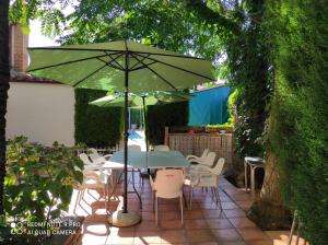 a table and chairs under an umbrella on a patio at CASA RURAL TRES VENTAS in Brazatortas