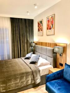 ein Schlafzimmer mit einem Bett und einem blauen Sofa in der Unterkunft Apartament Rodzinny Z Dużym Tarasem in Pogorzelica