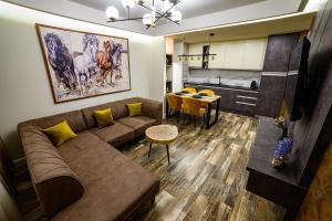 a living room with a couch and a table and a kitchen at Apartmani Milanovic in Bijeljina