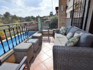 a balcony with a couch and chairs and a swimming pool at Belvilla by OYO Villa Orange in Algorfa