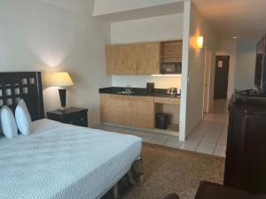 a bedroom with a large bed and a kitchen at Sunchase Inn & Suites in South Padre Island