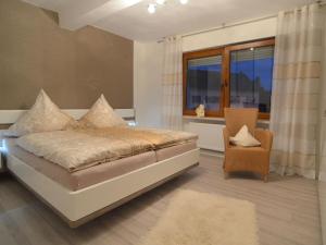 a bedroom with a bed and a chair and a window at Holiday home in Haserich with terrace in Haserich