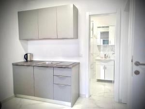 una cocina con armarios blancos y fregadero. en Apartment Bella en Novalja