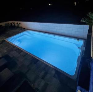 una piscina iluminada por la noche con luces azules en Apartment Bella en Novalja