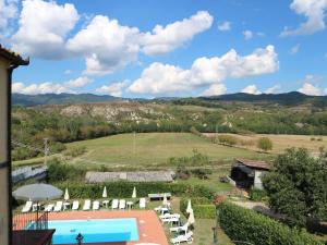 een uitzicht op een resort met een zwembad en stoelen bij Belvilla by OYO Villa Gaio in Vicchio