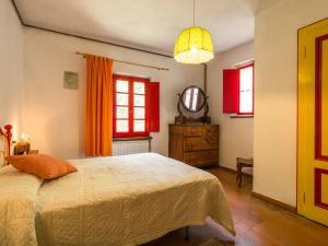 a bedroom with a bed and a dresser and windows at Belvilla by OYO Due Camini in San Marcello Pistoiese