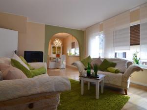 a living room with two couches and a table at Wonderful apartment with barrel sauna in Stockheim