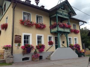 a building with flowers in front of it at Pichlerhof Sommmercard - Urlaub am Bauernhof in Birnberg