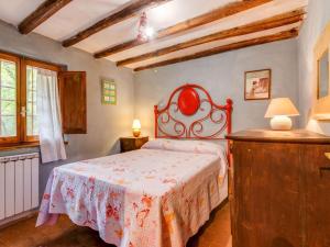 a bedroom with a bed with a red head board at Belvilla by OYO Loggetta in San Marcello Pistoiese