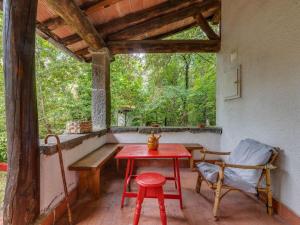 una mesa roja y una silla en un porche con ventana en Belvilla by OYO Loggetta, en San Marcello Pistoiese