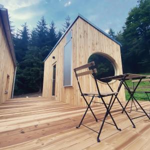 a chair on a wooden deck with a building at Zinipi Retreat Gelenau "Eber" in Wiltzsch