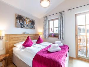 ニーダーンジルにあるModern Chalet with Sauna in Niedernsillのベッドルーム1室(ピンクの枕が付いた大型ベッド1台付)