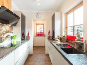 a kitchen with white cabinets and a counter top at Modern Chalet with Sauna in Niedernsill in Niedernsill