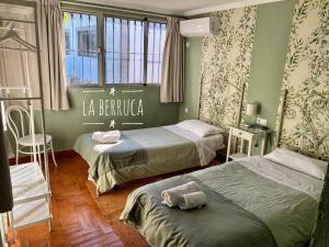 Habitación de hotel con 2 camas y ventana en La Berruca Casa Rural Malpartida de Cáceres en Malpartida de Cáceres