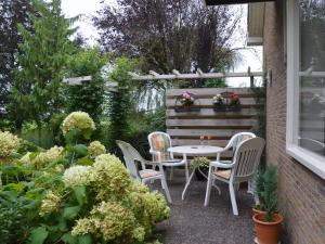 un patio con mesa y sillas en un jardín en Cozy vacation home with a private garden, en Mantinge