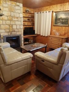 a living room with two chairs and a fireplace at Chalet Malmedy in Malmedy