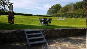 a table and chairs sitting next to a stone wall at Chalet Malmedy in Malmedy
