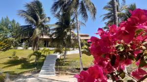 uma casa com palmeiras e flores rosas em Villa Jodie Fortim em Fortim