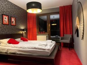 ユラタにあるApartament Hong Kongのベッドルーム1室(赤いカーテンと椅子付きのベッド1台付)