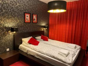 a bedroom with a bed with red curtains and a red curtain at Apartament Hong Kong in Jurata