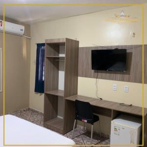a room with a desk with a tv and a chair at Grand Center Hotel in Santar&eacute;m