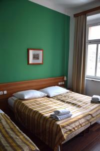 ein Schlafzimmer mit einem Bett mit einer grünen Wand in der Unterkunft Hotel Residence Select in Prag