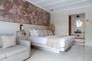 a white bedroom with a large bed and a couch at Refúgio na Serra Boutique Hotel in Mucugê