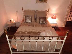 a bedroom with a white bed with two pillows at La villa Bherte dé cil in Aire-sur-lʼAdour