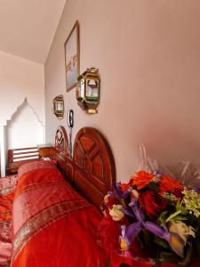 a bedroom with a bed with flowers on it at Hotel Tachfine in Marrakesh