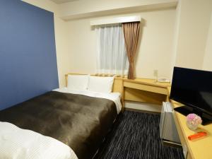 Postel nebo postele na pokoji v ubytování Nagoya Sakae Green Hotel