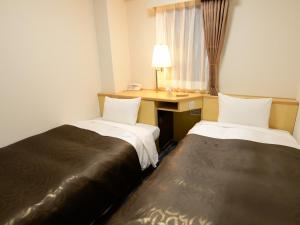 Postel nebo postele na pokoji v ubytování Nagoya Sakae Green Hotel