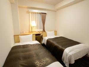 Postel nebo postele na pokoji v ubytování Nagoya Sakae Green Hotel