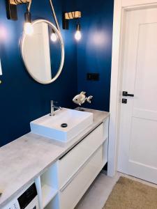 y baño con lavabo blanco y espejo. en Apartament by Karol, en Międzywodzie