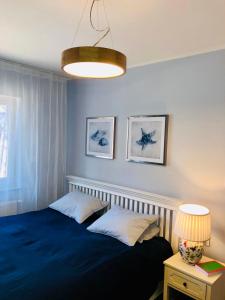 a bedroom with a blue bed and a lamp at Apartament by Karol in Międzywodzie