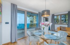 salon ze szklanym stołem i krzesłami w obiekcie Villa Njivice Apartment Ema w mieście Nijvice