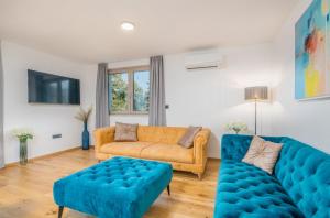 salon z kanapą i niebieską kanapą w obiekcie Villa Njivice Apartment Ema w mieście Nijvice