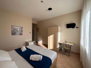a bedroom with a bed and a desk with a television at Al Centro in Verbania