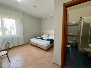 a small bedroom with a bed and a bathroom at Al Centro in Verbania