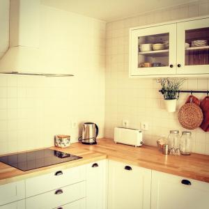 a kitchen with white cabinets and a counter top at CASA ANDORINHAS in Fontainhas